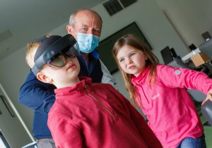http://A%20researcher%20demonstrating%20virtual%20reality%20to%20two%20children