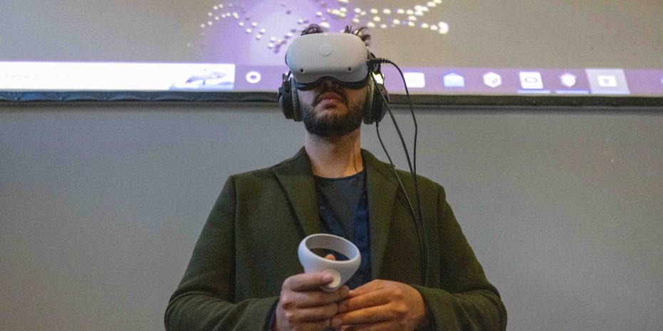man wearing a virtual reality headset, holding a controller, looking upwards