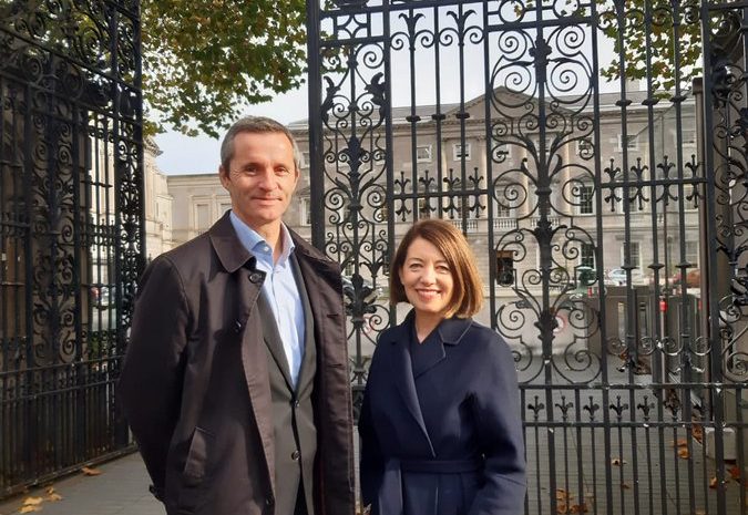 Professor Linda Hogan and Dr Ciaran Seioghe standing outside the gate of Leinster House