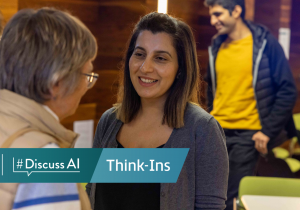 http://Two%20women%20speaking%20at%20an%20ADAPT%20#DiscussAI%20Think-In.%20In%20the%20background%20there%20is%20a%20man%20in%20a%20yellow%20shirt%20and%20blue%20jacket.