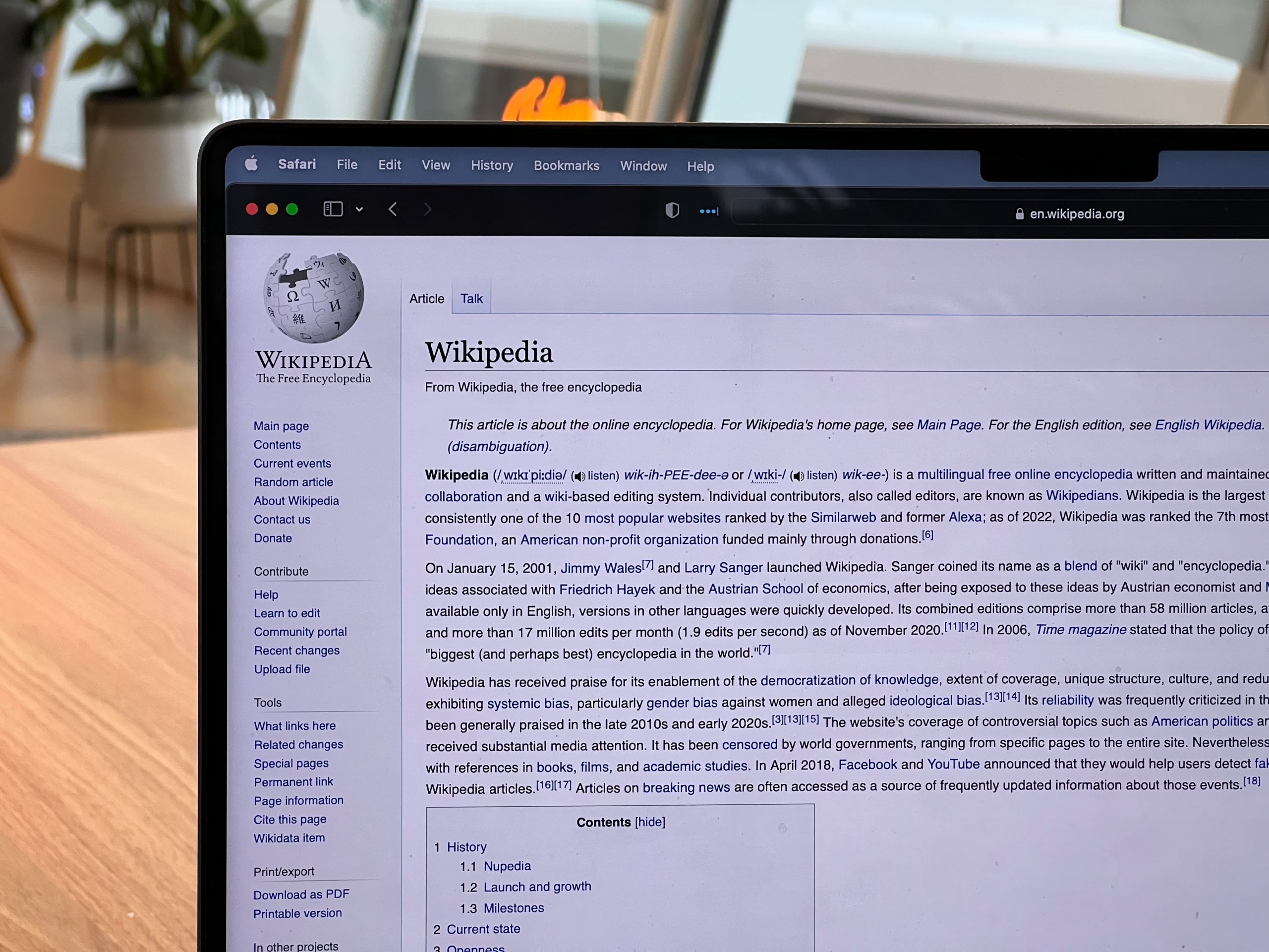 A laptop screen with the Wikipedia homepage. There is a lot of text on the homepage, describing wikipedia.