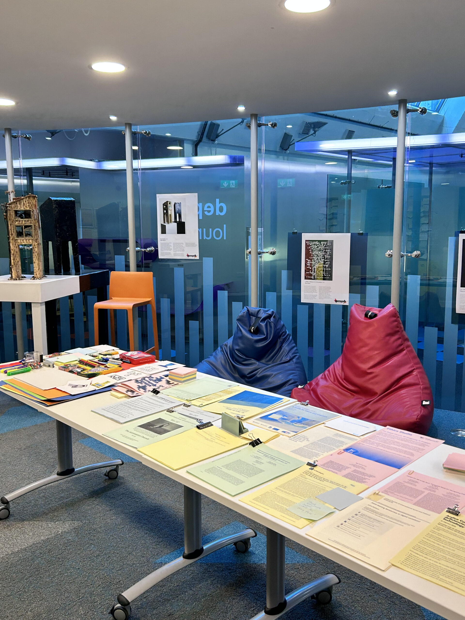 a long table in a glass room. There are resources and interactive materials on the long table.