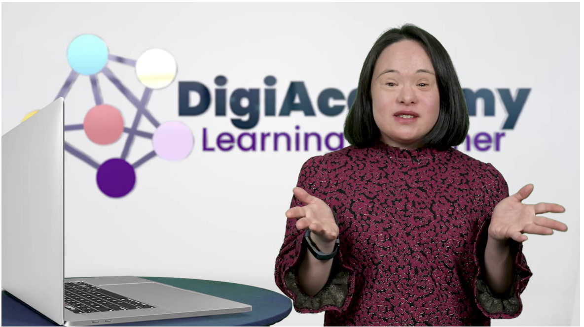 Photo of DigiAcademy instructor Mei Lin Yap presenting at a laptop with the DigiAcademy logo behind her