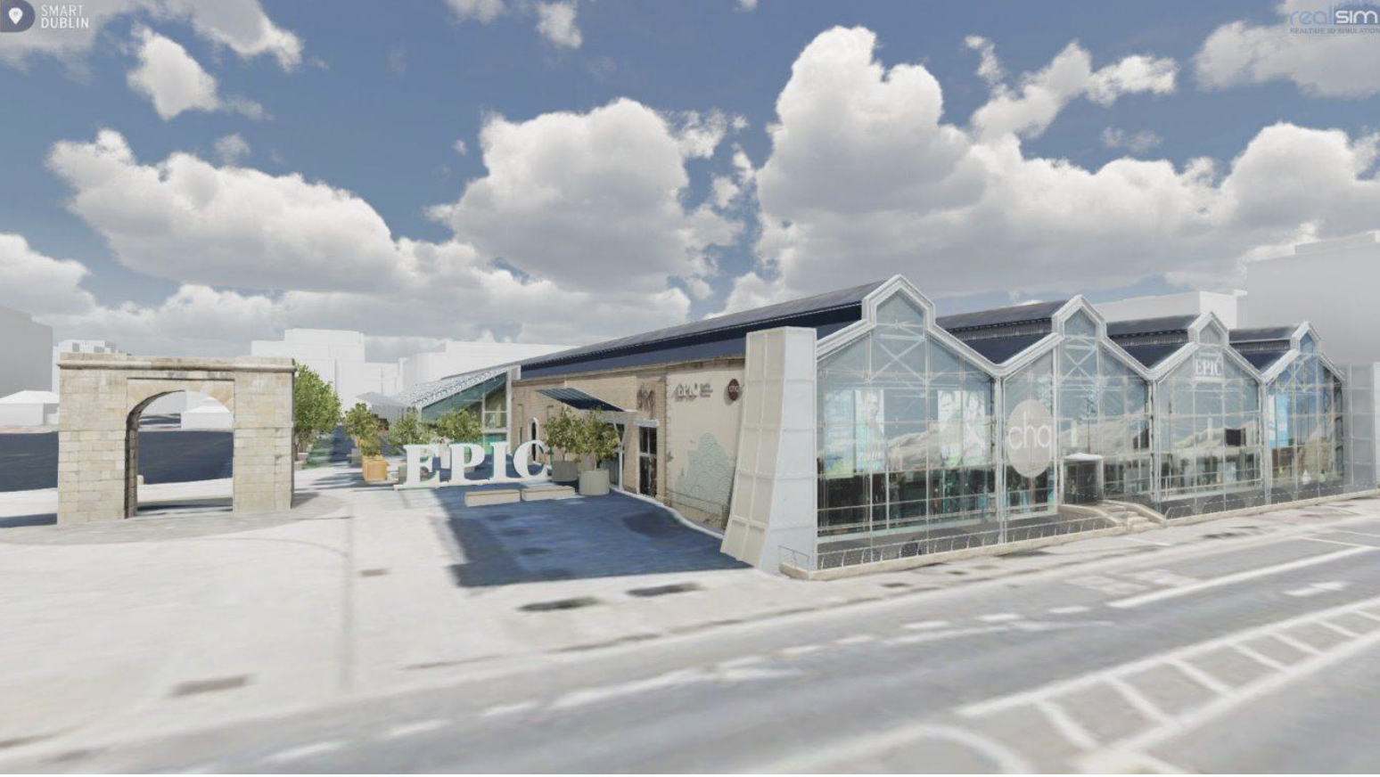 A realistic 3D model of a building with a glass-fronted, greenhouse-style design, a sign that reads "EPIC" in front, and a weathered stone archway to the left. The scene is shown under a blue sky with fluffy clouds.