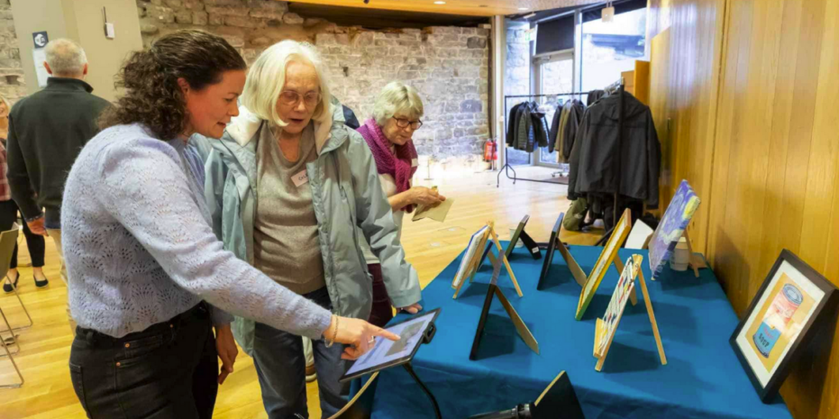 two women engaging with an exhibit at an event